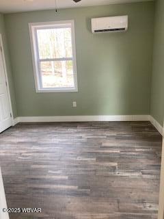 131 Spring House Rd, Muncy Valley, PA 17758 - unfurnished room with baseboards, a ceiling fan, a wall unit AC, and wood finished floors