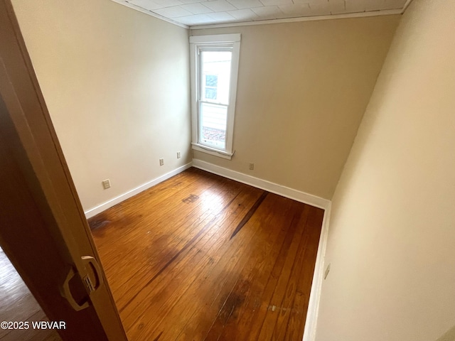 unfurnished room featuring wood-type flooring and ornamental molding