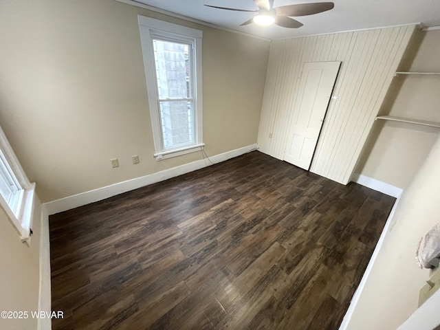 unfurnished bedroom with ceiling fan, a closet, and dark wood-type flooring