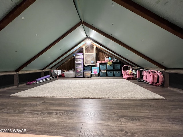 additional living space with wood-type flooring and vaulted ceiling