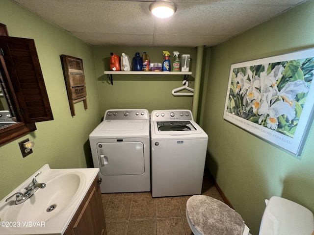 washroom featuring sink, dark tile patterned floors, and washer and dryer