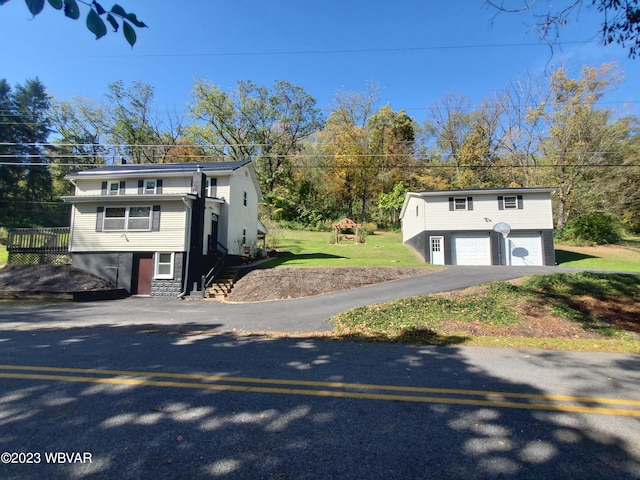 raised ranch with an outbuilding, a garage, and a front lawn