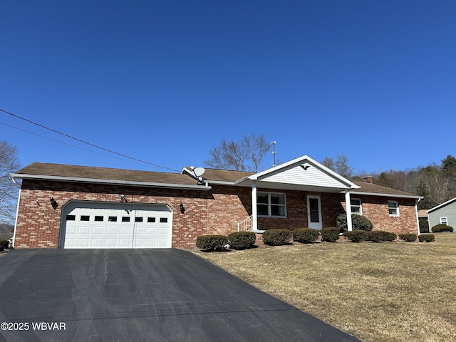 ranch-style home with aphalt driveway, a front yard, an attached garage, brick siding, and a chimney