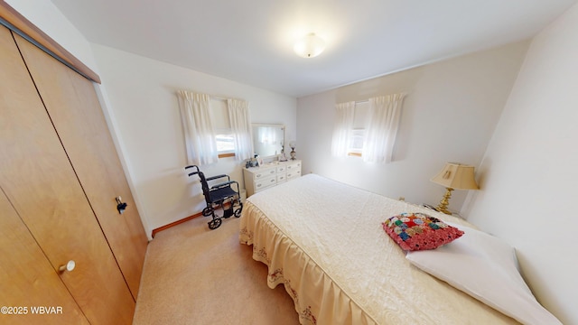 bedroom featuring light colored carpet, a closet, and baseboards