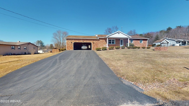 view of front of house with a garage, brick siding, and a front yard