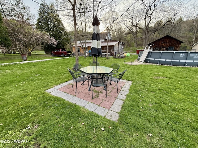 view of yard featuring an outdoor pool and a patio