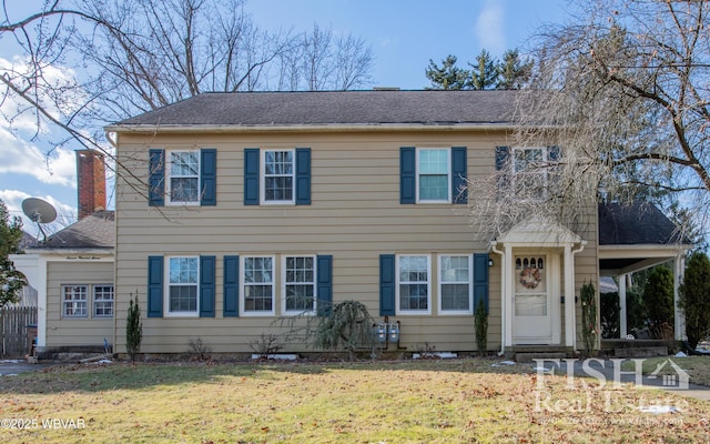 colonial-style house featuring a front yard