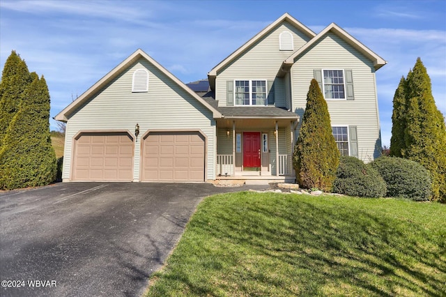 view of property with a garage and a front lawn