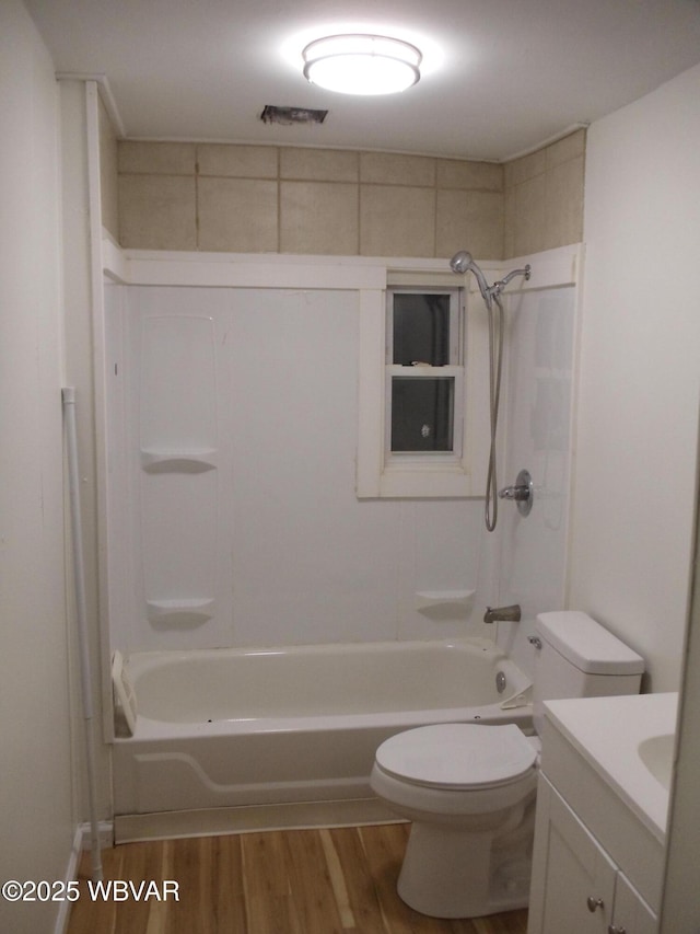 full bathroom featuring washtub / shower combination, vanity, hardwood / wood-style flooring, and toilet