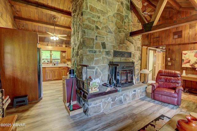 1640 Pleasant Valley Rd, Cogan Station, PA 17728 - living area with wood ceiling with exposed beams, light wood-style flooring, wood walls, a ceiling fan, and a stone fireplace