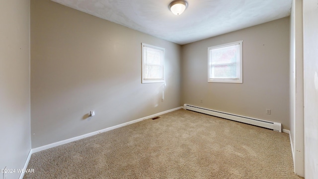 unfurnished room featuring light carpet and a baseboard heating unit