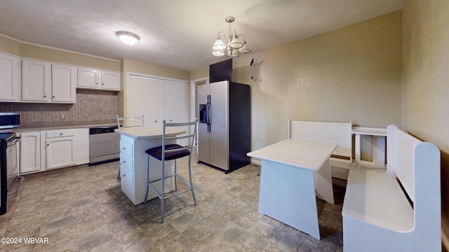 kitchen with a center island, white cabinetry, stainless steel appliances, and hanging light fixtures