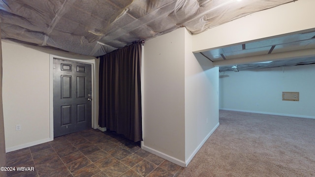 basement featuring dark carpet