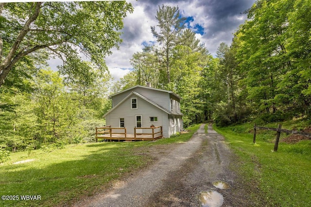 1462 Highland Lake Rd, Hughesville, PA 17737 - view of front of house with driveway, a deck, a front yard, and a view of trees