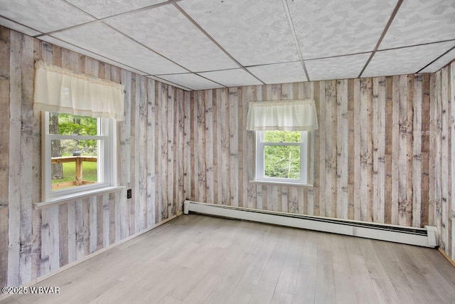 1462 Highland Lake Rd, Hughesville, PA 17737 - empty room with plenty of natural light, wood finished floors, baseboard heating, and a paneled ceiling