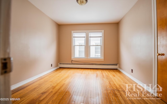 empty room with baseboard heating and light wood-type flooring