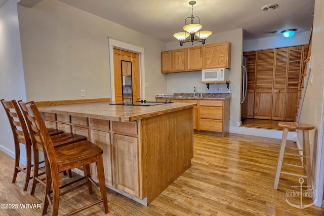2312 Teaberry Ln, Lock Haven, PA 17745 - kitchen featuring visible vents, white microwave, light wood finished floors, and freestanding refrigerator