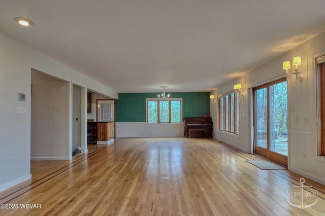 2312 Teaberry Ln, Lock Haven, PA 17745 - unfurnished living room with light wood finished floors, an inviting chandelier, and baseboards