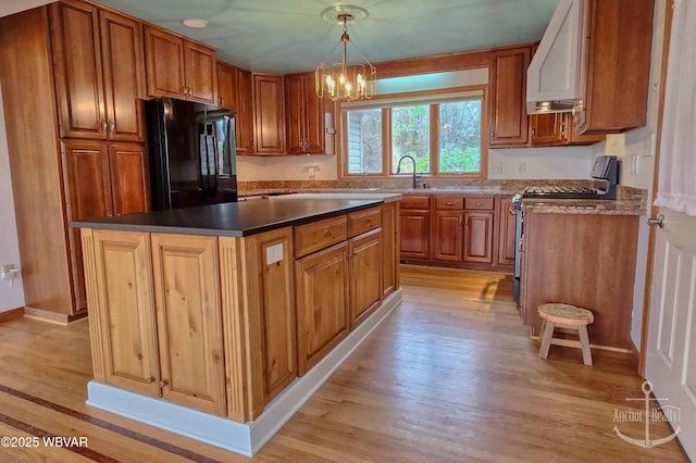 2312 Teaberry Ln, Lock Haven, PA 17745 - kitchen with light wood-style flooring, freestanding refrigerator, stainless steel gas stove, extractor fan, and a notable chandelier