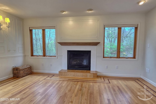 2312 Teaberry Ln, Lock Haven, PA 17745 - unfurnished living room featuring wood finished floors, a healthy amount of sunlight, and a tiled fireplace