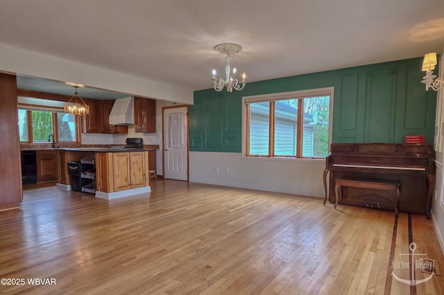 2312 Teaberry Ln, Lock Haven, PA 17745 - kitchen featuring black dishwasher, dark countertops, light wood-type flooring, a notable chandelier, and wall chimney exhaust hood