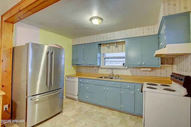 kitchen featuring white appliances, blue cabinets, and sink