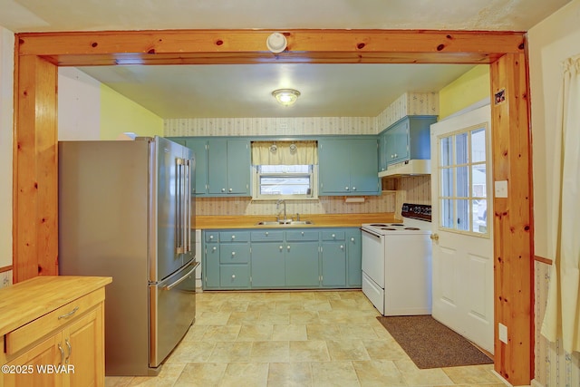 kitchen with sink, white electric stove, high end refrigerator, and blue cabinets