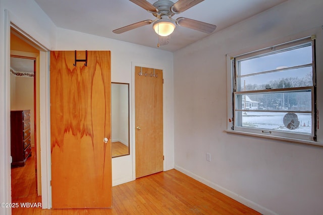 unfurnished bedroom with ceiling fan and light wood-type flooring