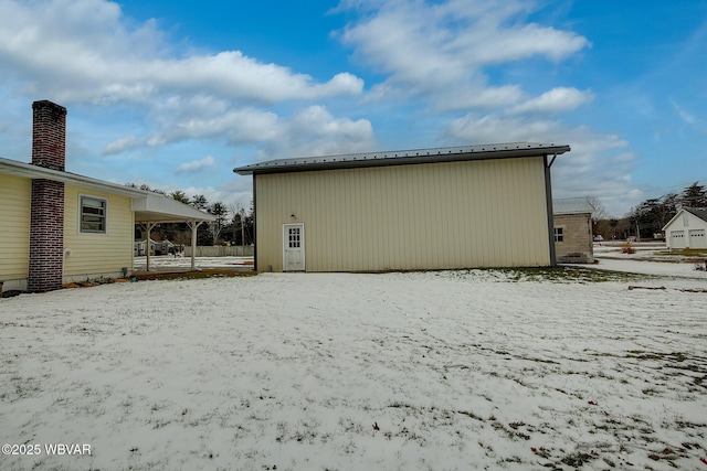 view of snow covered rear of property