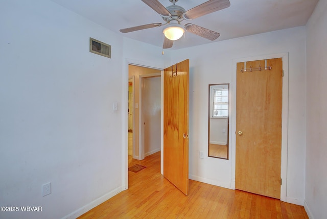 unfurnished bedroom featuring light wood-type flooring, ceiling fan, and a closet