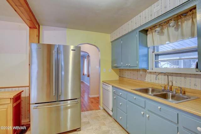 kitchen with dishwasher, high quality fridge, and sink