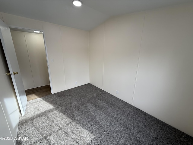 carpeted spare room with lofted ceiling