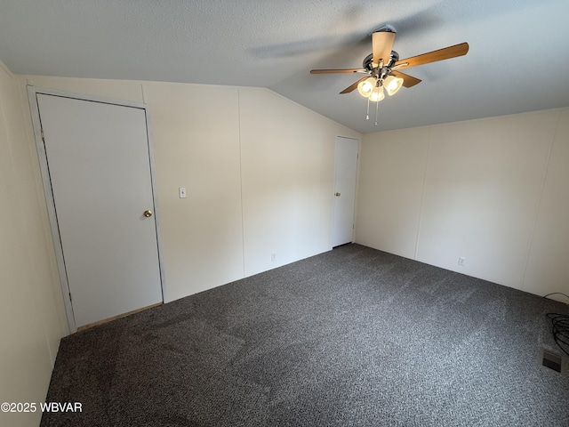 unfurnished room with carpet, a textured ceiling, vaulted ceiling, and ceiling fan