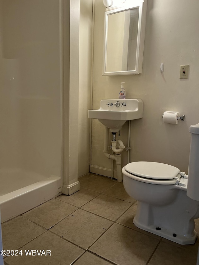 bathroom featuring toilet, a shower, and tile patterned floors