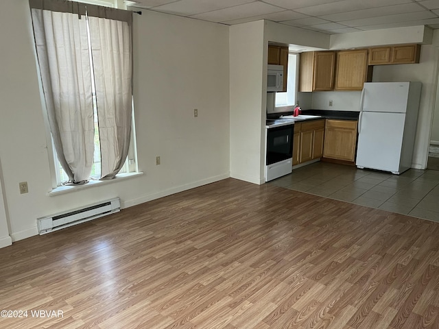 kitchen featuring hardwood / wood-style floors, a healthy amount of sunlight, white appliances, and a baseboard heating unit