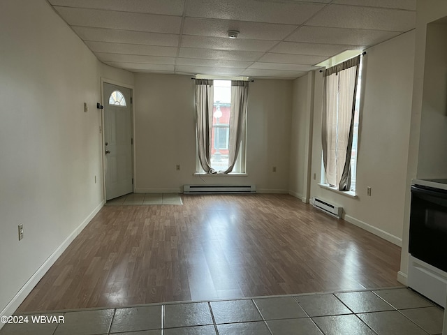 foyer featuring wood-type flooring, a drop ceiling, and a baseboard heating unit