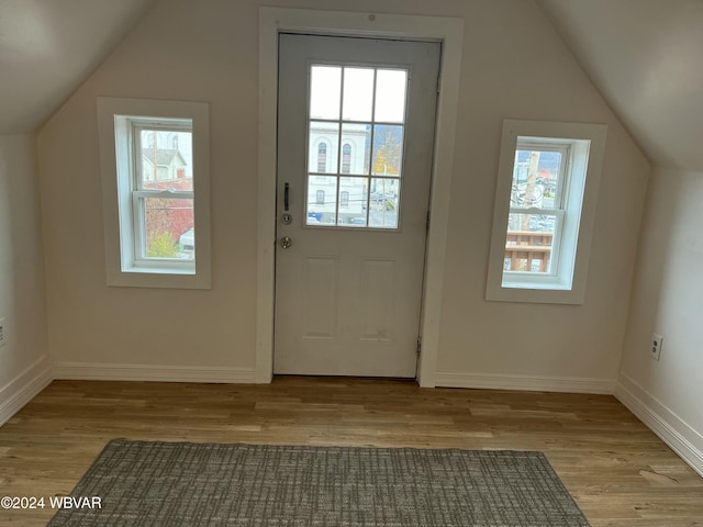 additional living space with lofted ceiling, light hardwood / wood-style flooring, and a healthy amount of sunlight