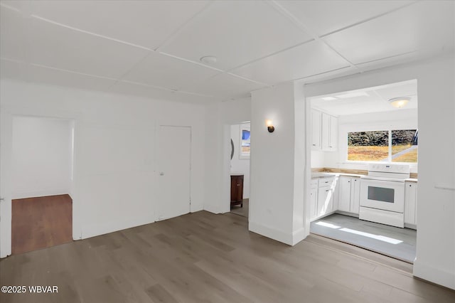 interior space with baseboards, a paneled ceiling, and light wood-style flooring