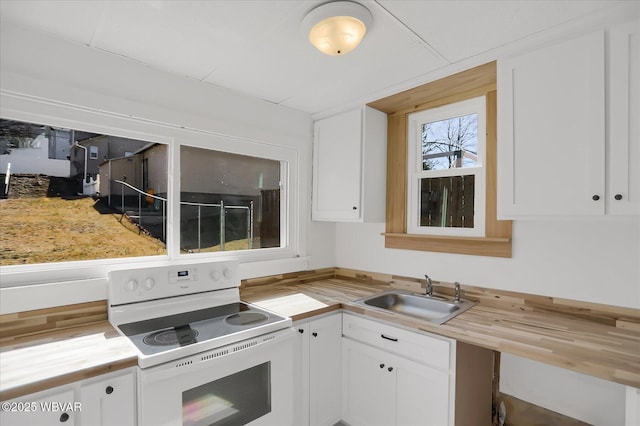 kitchen featuring wood counters, electric range, white cabinetry, and a sink