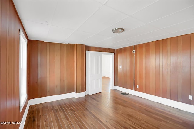 spare room with visible vents, baseboards, and hardwood / wood-style floors