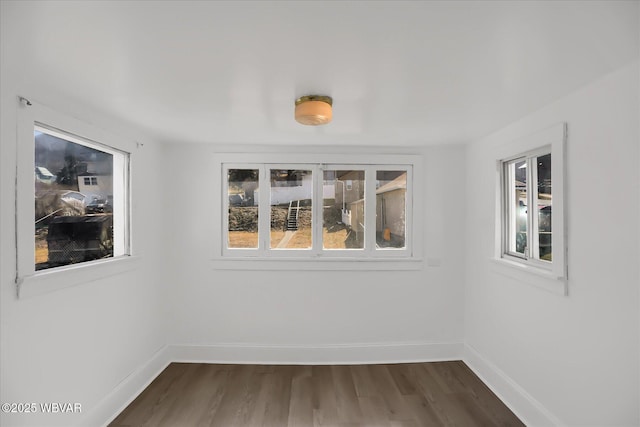 unfurnished room featuring dark wood-style floors and baseboards