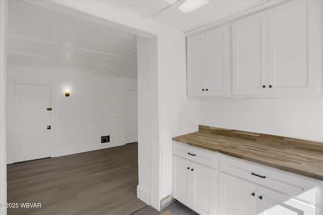 kitchen with dark wood finished floors, white cabinets, and butcher block counters