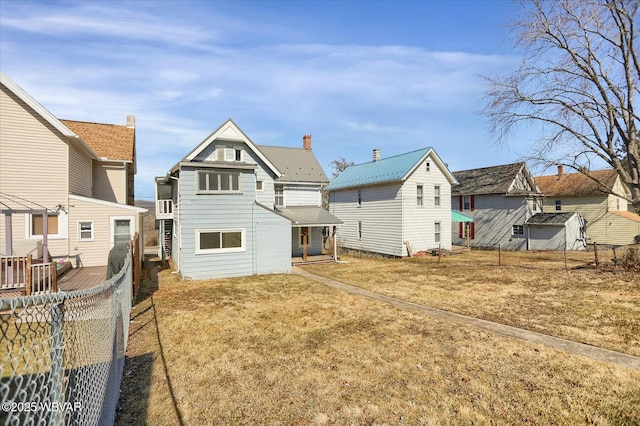 back of property with metal roof and fence