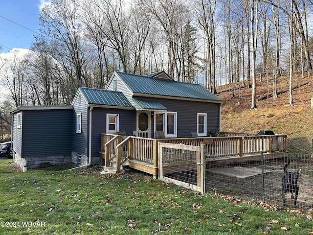 rear view of property with a lawn and a wooden deck