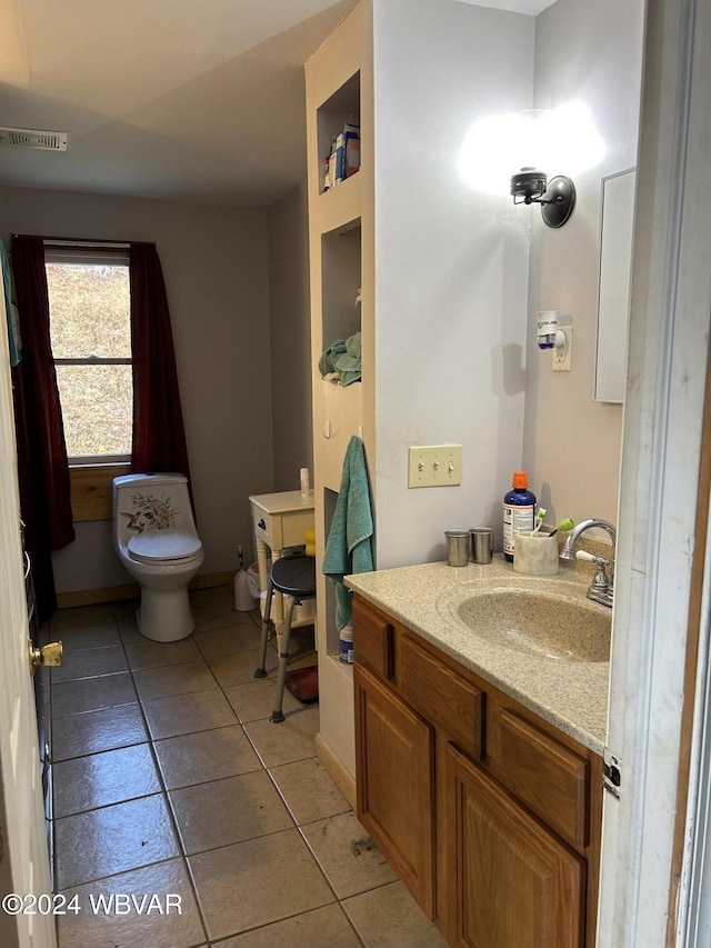 bathroom with tile patterned flooring, vanity, and toilet