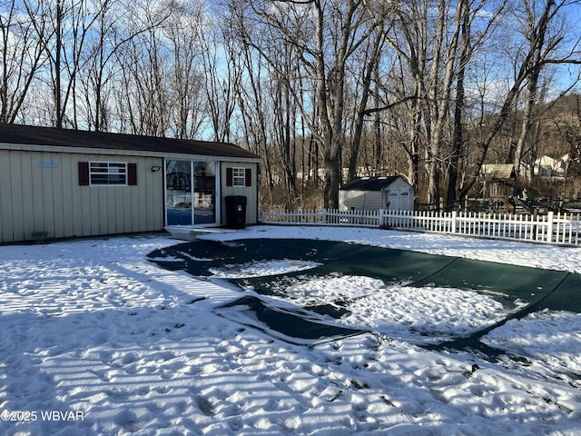 snow covered pool with a shed