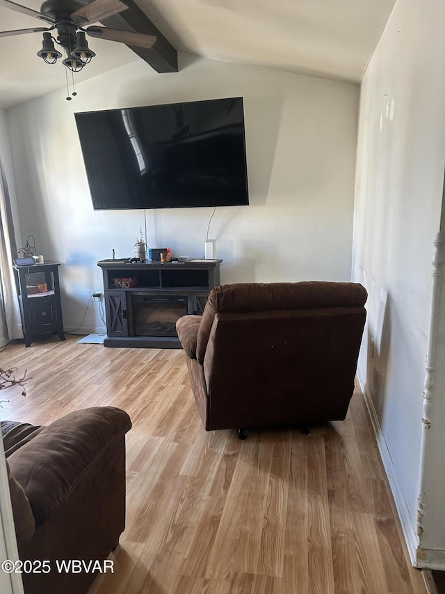 living room with lofted ceiling, ceiling fan, and light hardwood / wood-style flooring