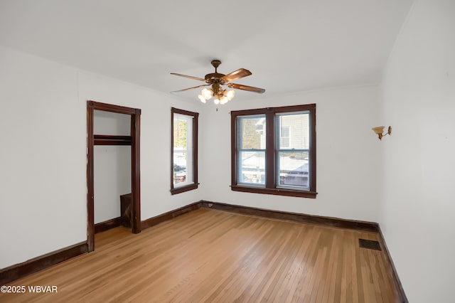 unfurnished bedroom featuring ceiling fan, light hardwood / wood-style floors, and a closet