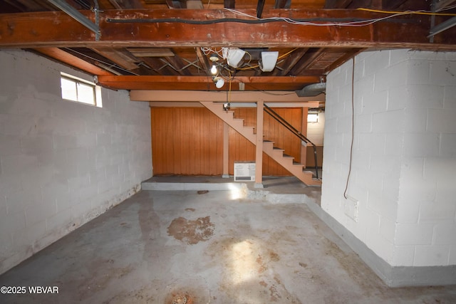 basement featuring stairs and concrete block wall