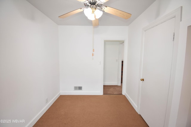 empty room featuring baseboards, visible vents, ceiling fan, and carpet flooring